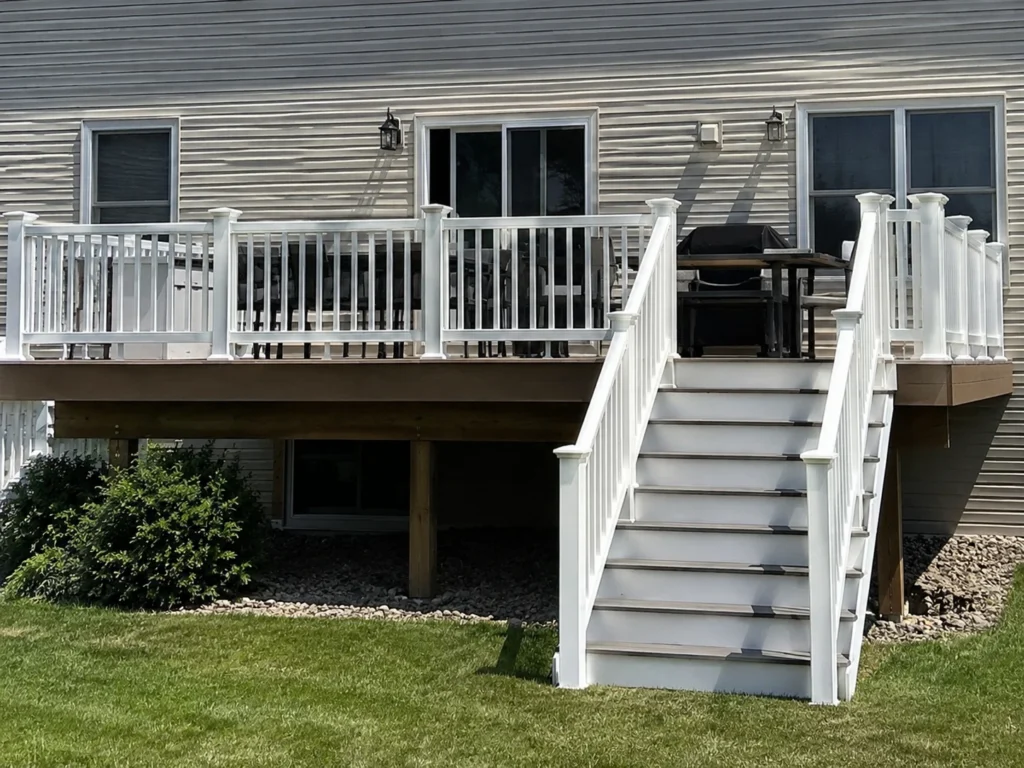 Finished elevated deck with white railing and stairs in Iowa City, Iowa.
