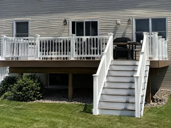 Finished elevated deck with white railing and stairs in Iowa City, Iowa.