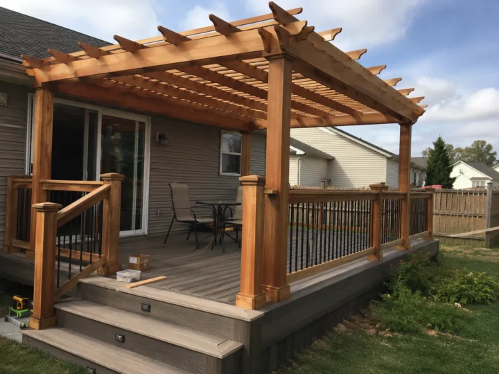 Finished pergola deck with wood railing in Solon, Iowa.