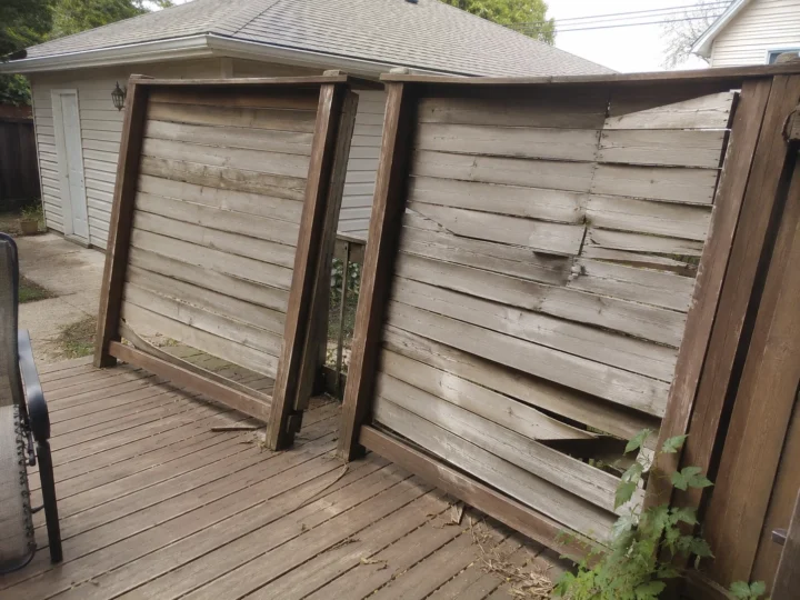 Weathered wood privacy screen before repair in Swisher, Iowa.