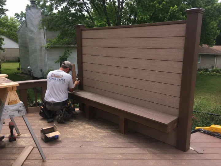 Worker assembling tall horizontal privacy screen on a residential deck project in Iowa City, Iowa.