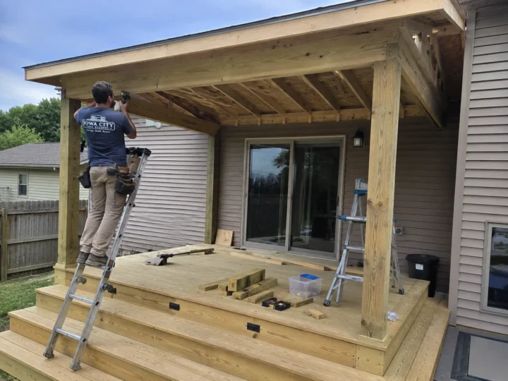 Worker framing covered deck roof on a residential deck project in Lone Tree, Iowa.
