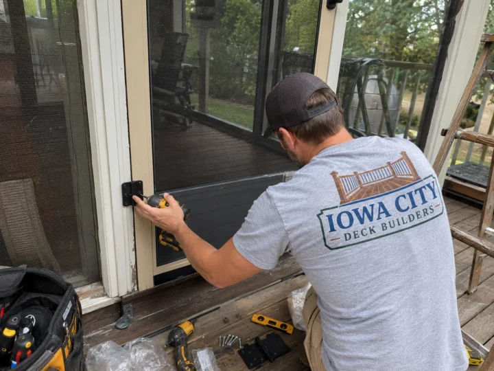 Worker repairing deck to door transition on a residential deck project in Nichols, Iowa.