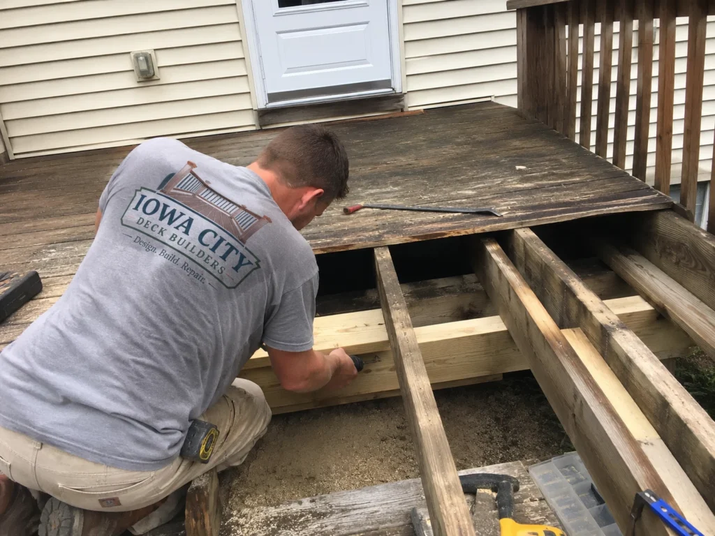 Workers rebuilding weathered deck surface on a residential deck project in Tiffin, Iowa.